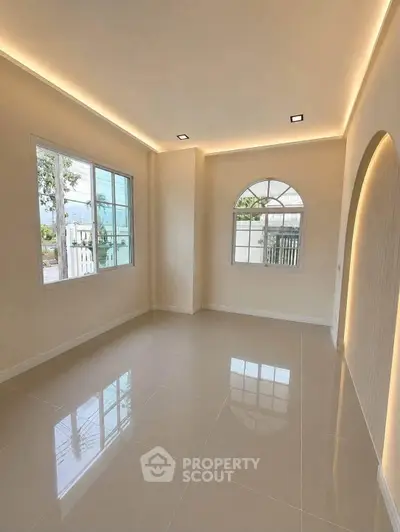 Spacious and bright living room with modern lighting and large windows