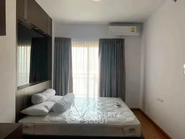 Modern bedroom with natural light, featuring a comfortable bed and air conditioning, ideal for restful living.
