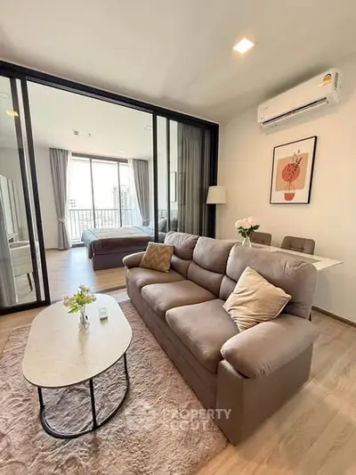 Modern living room with cozy sofa and dining area in open-plan apartment