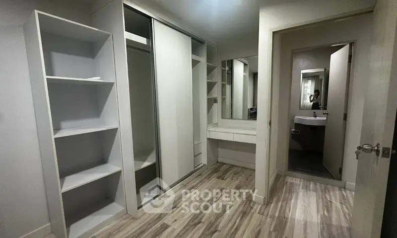 Spacious walk-in closet with modern shelving and mirror in a stylish home.