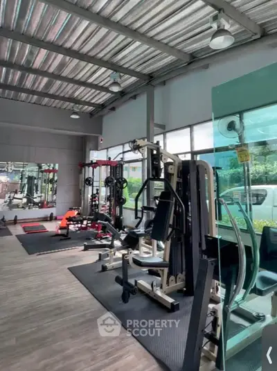 Modern gym with state-of-the-art equipment and large windows for natural light.