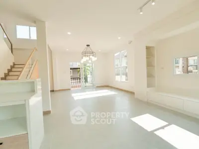 Spacious modern living room with large windows and elegant lighting