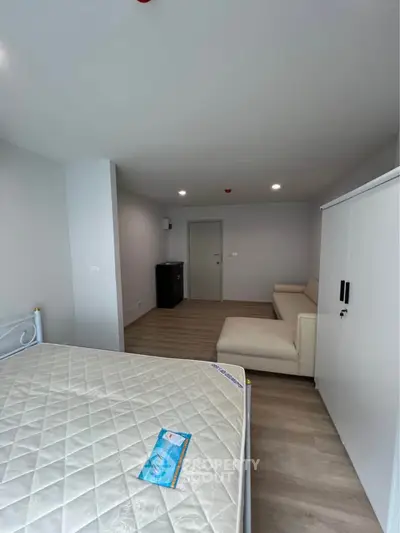 Spacious modern bedroom with minimalist decor and ample natural light.