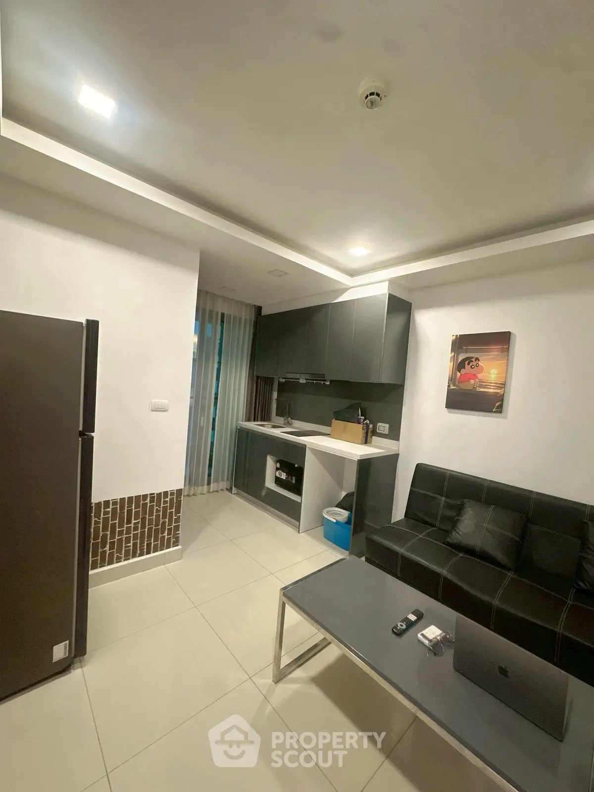 Modern studio apartment with sleek kitchen and cozy living area.