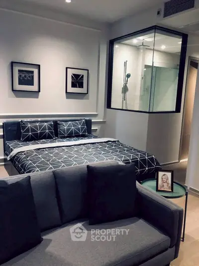 Modern bedroom with stylish decor and glass shower enclosure