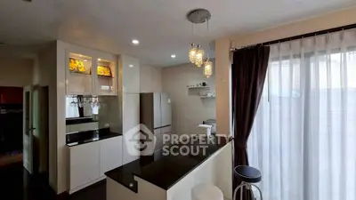 Modern kitchen with sleek design, featuring a breakfast bar and stylish pendant lighting.