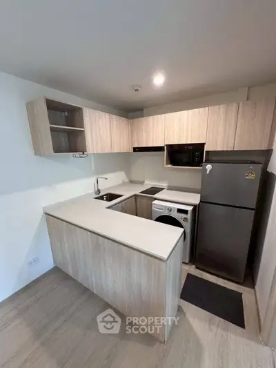 Modern kitchen with sleek cabinetry and appliances in compact layout