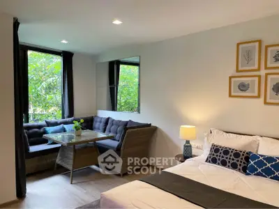 Cozy bedroom with stylish decor and a charming seating area by the window.