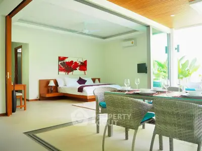 Luxurious open-plan bedroom with dining area and garden view, featuring modern decor and elegant furnishings.