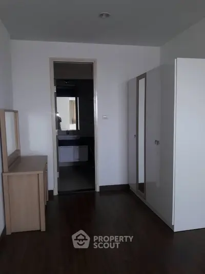Modern bedroom with sleek wooden flooring and minimalist furniture design.