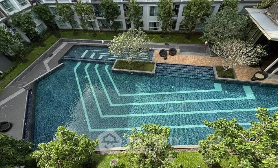 Luxurious apartment complex with stunning outdoor pool and lush greenery, perfect for relaxation and leisure.