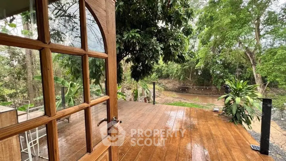 Charming wooden deck with lush garden view, perfect for outdoor relaxation.