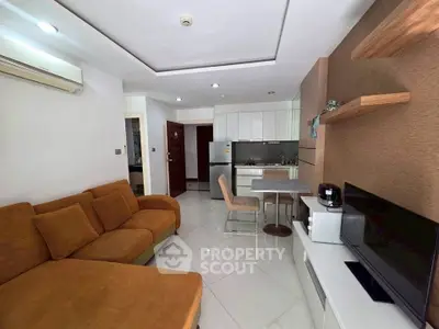 Modern living room with open kitchen, featuring sleek furniture and contemporary design.