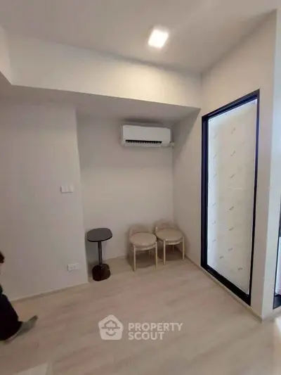 Modern minimalist room with air conditioning and light wood flooring