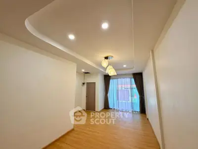 Spacious living room with elegant lighting and large window for natural light.