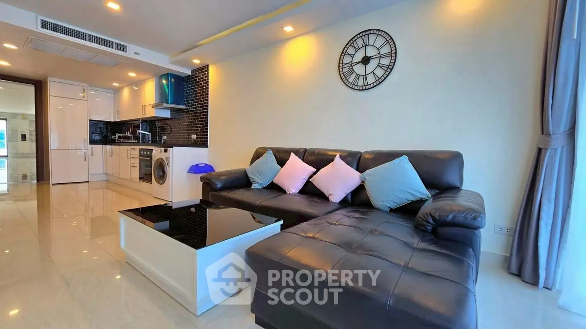 Modern living room with sleek black sofa and open kitchen layout