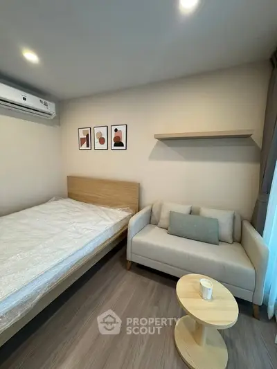 Modern bedroom with cozy sofa and stylish decor in a well-lit apartment