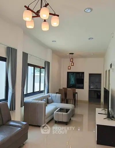 Spacious modern living room with elegant lighting and stylish furniture, perfect for relaxation and entertainment.