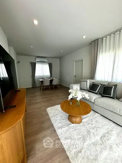 Modern living room with elegant decor and cozy dining area, featuring stylish furniture and natural light.