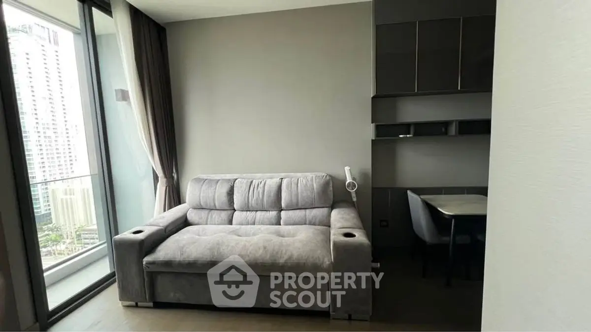 Modern living room with grey sofa and city view balcony in luxury apartment