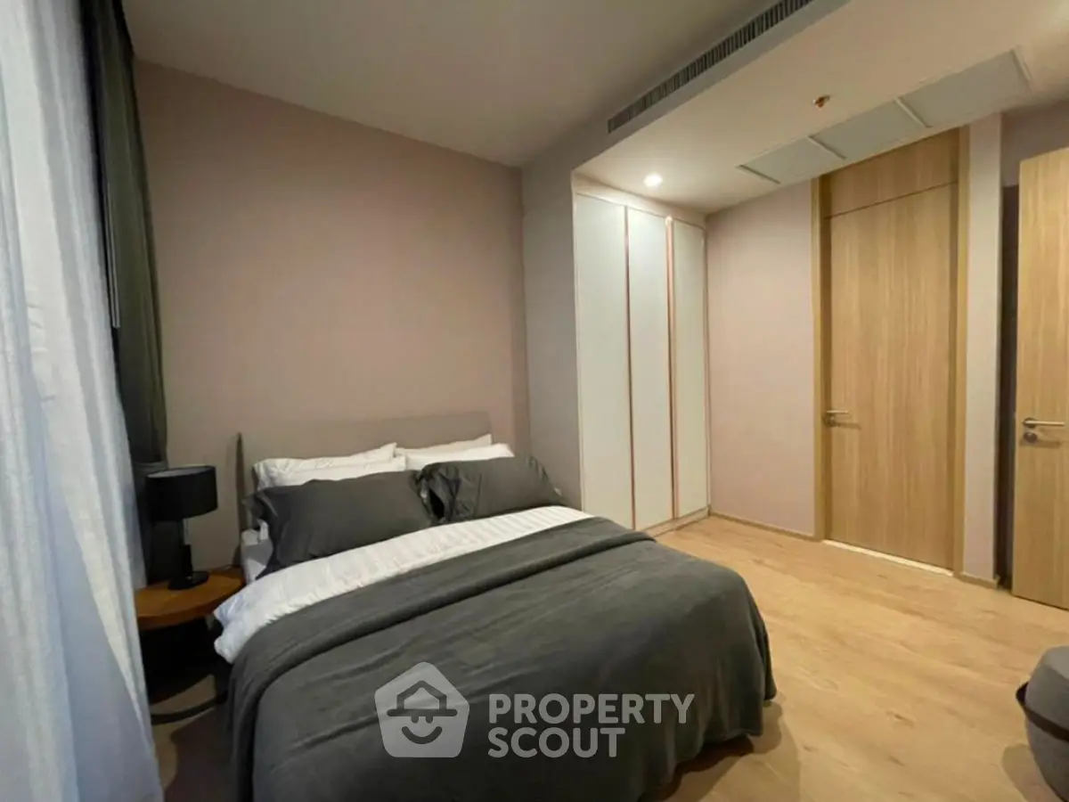 Modern bedroom with cozy bedding and sleek wooden flooring