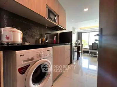 Modern kitchen with washing machine and sleek cabinetry in a bright apartment