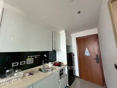 Modern kitchen with sleek cabinets and compact appliances in a cozy apartment.