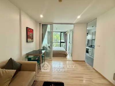 Modern open-plan living room with cozy bedroom and stylish kitchen in a bright apartment.