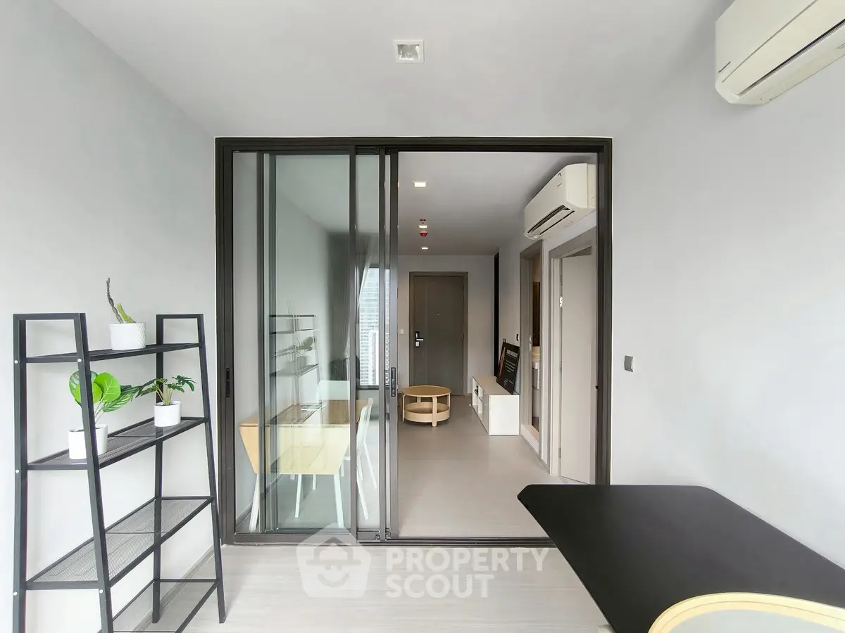 Modern minimalist apartment interior with sliding glass doors and sleek furniture.
