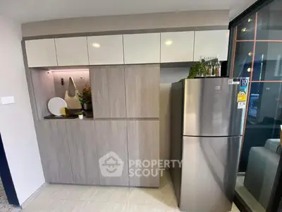Modern kitchen with sleek cabinetry and stainless steel fridge in stylish apartment