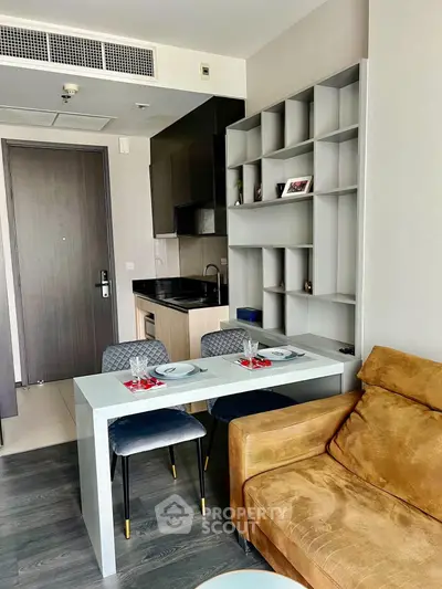 Modern apartment interior with stylish kitchen and cozy living area, featuring elegant dining setup and contemporary decor.