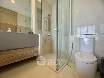 Modern bathroom with glass shower and sleek fixtures in a contemporary home.