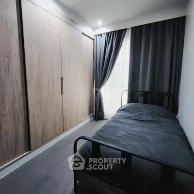 Modern bedroom with sleek black bed and large wooden wardrobe