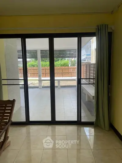 Spacious living room with sliding glass doors leading to a covered patio area, perfect for indoor-outdoor living.