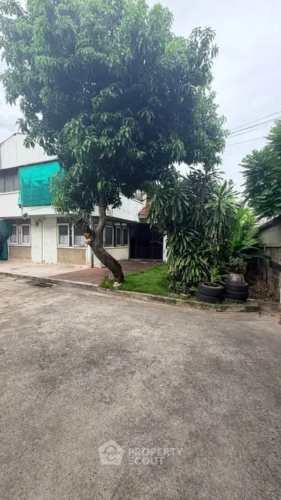 Charming suburban home with lush greenery and spacious driveway, perfect for family living.