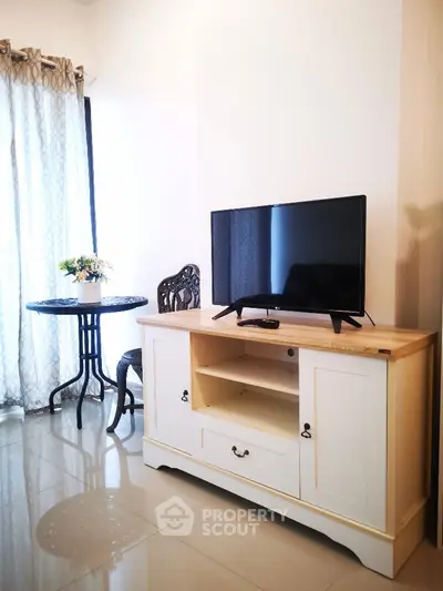 Charming living room with elegant TV stand and cozy dining nook, perfect for relaxation and entertainment.
