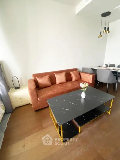 Modern living room with stylish brown sofa and elegant black coffee table in a cozy apartment.
