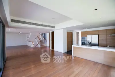 Spacious modern living room with open kitchen and wooden flooring