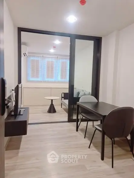 Modern living room with sleek furniture and glass partition in a stylish apartment.