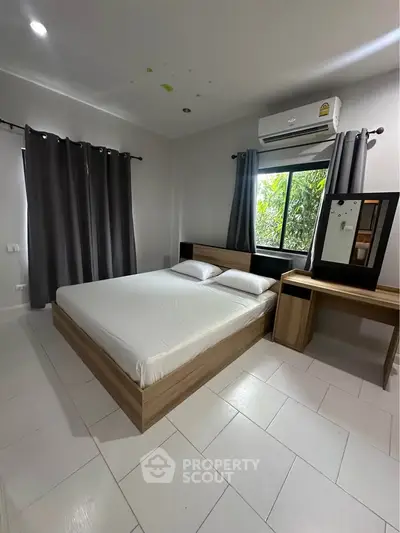 Spacious bedroom with modern furnishings and natural light