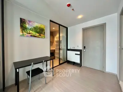 Modern apartment interior with sleek kitchen and dining area, featuring minimalist design and natural light.