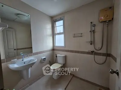 Modern bathroom with sleek fixtures and wall-mounted shower in a contemporary home.