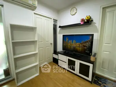 Cozy living room with modern entertainment unit, built-in shelving, and elegant hardwood flooring, perfect for relaxing and entertaining guests.