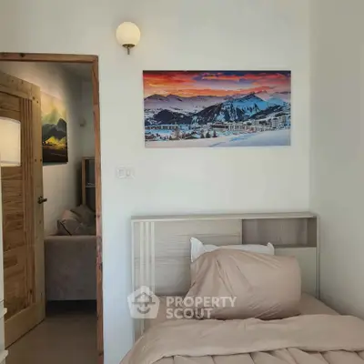 Cozy bedroom with mountain view artwork and wooden accents