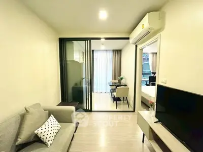 Modern living room with air conditioning and sliding glass doors leading to a dining area.