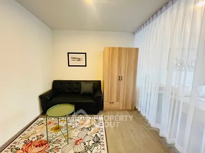 Cozy living room with modern sofa, stylish rug, and elegant wardrobe in a bright, airy space.