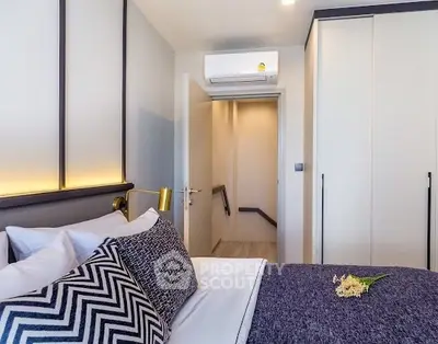 Modern bedroom with stylish decor and built-in wardrobe, featuring a cozy ambiance.