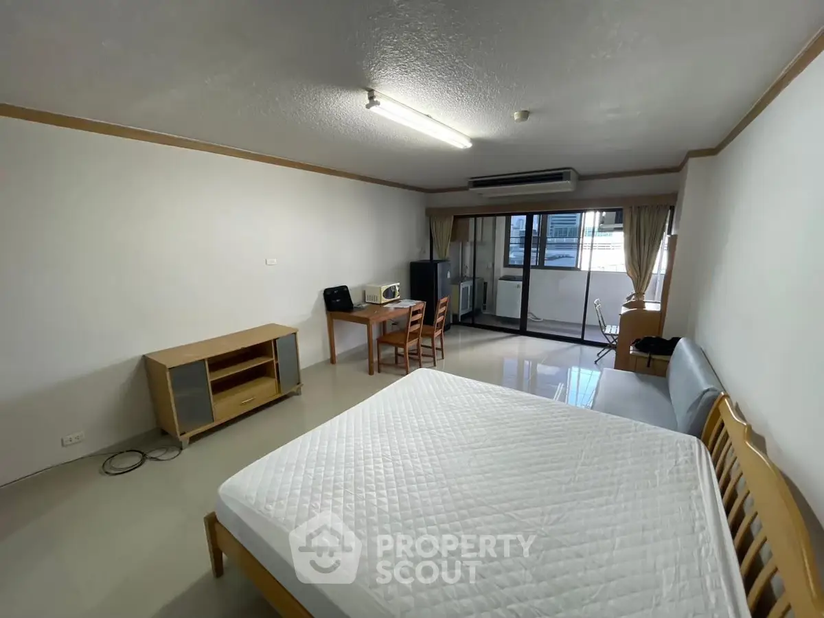 Spacious studio apartment with large windows and modern furnishings in a prime location.