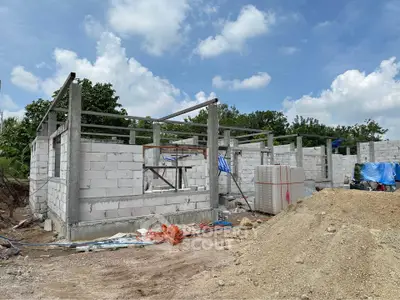 Under-construction building site with concrete block walls and open sky view.