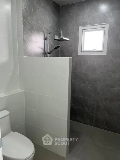 Modern bathroom with sleek gray tiles and a walk-in shower design.